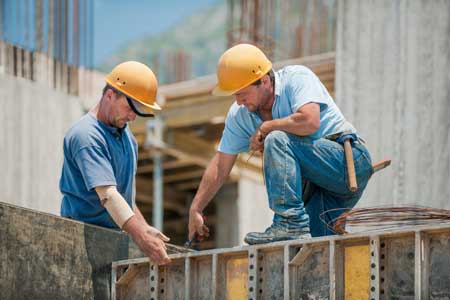 Construction workers setting concrete forms